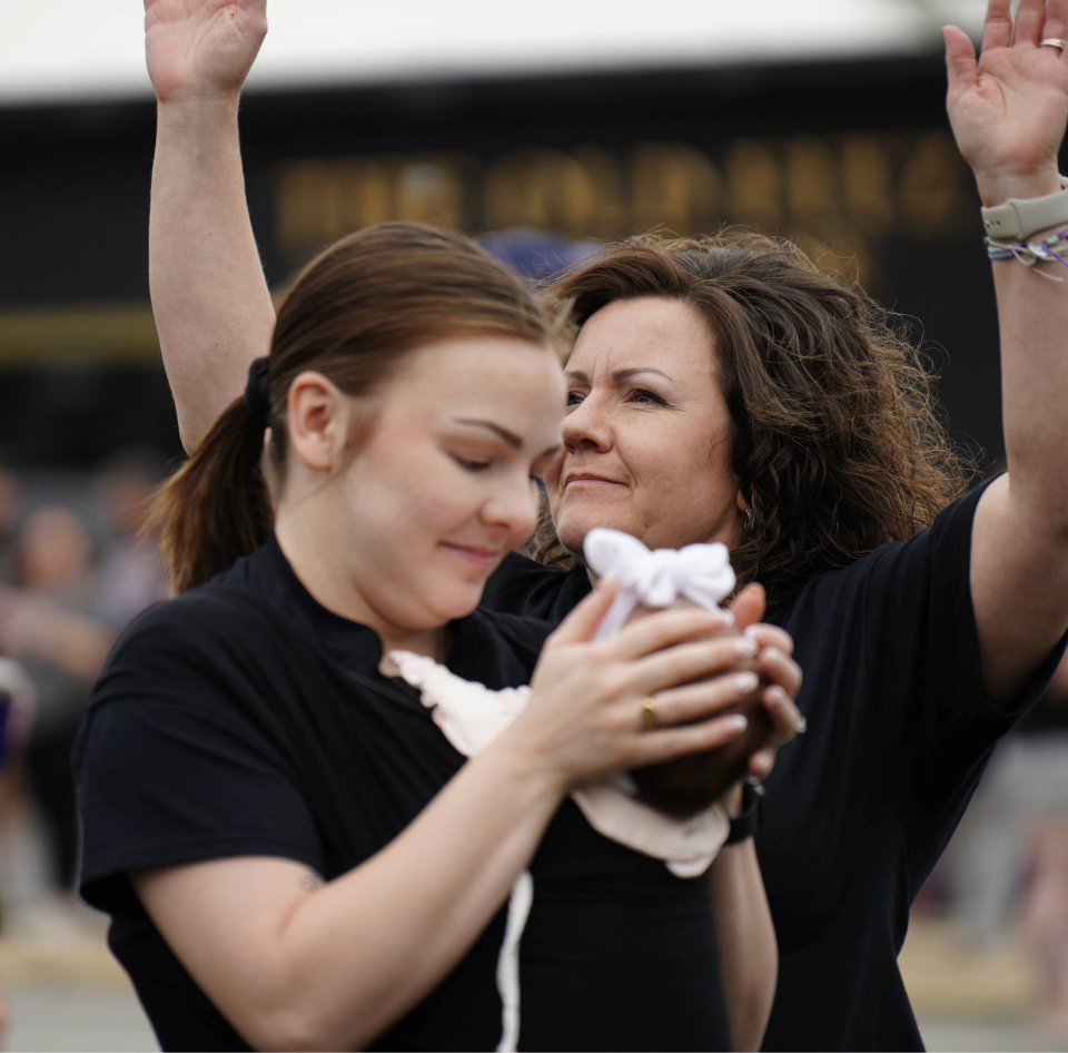 Two people in the crowd enjoying the Cancer Services Walk of Hope, with music and entertainment provided by RoLo Entertainment as longtime DJ and emcee.